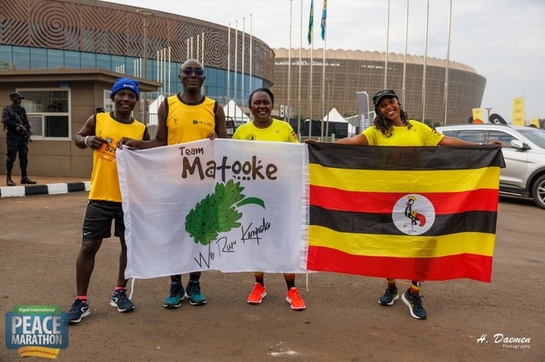Four people in yellow shirts holding Matooke and Uganda flags at a peace marathon event