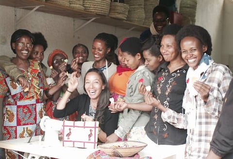 Group of diverse women gathered around a table at a celebration or party, smiling and enjoying each others company