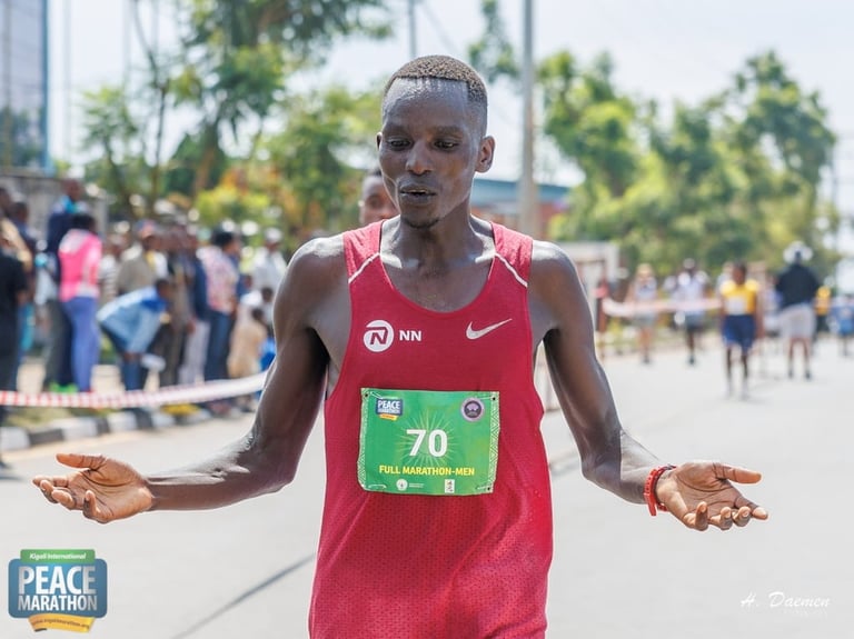 Male marathon runner in red NN Nike bib finishing race on city street with spectators in background
