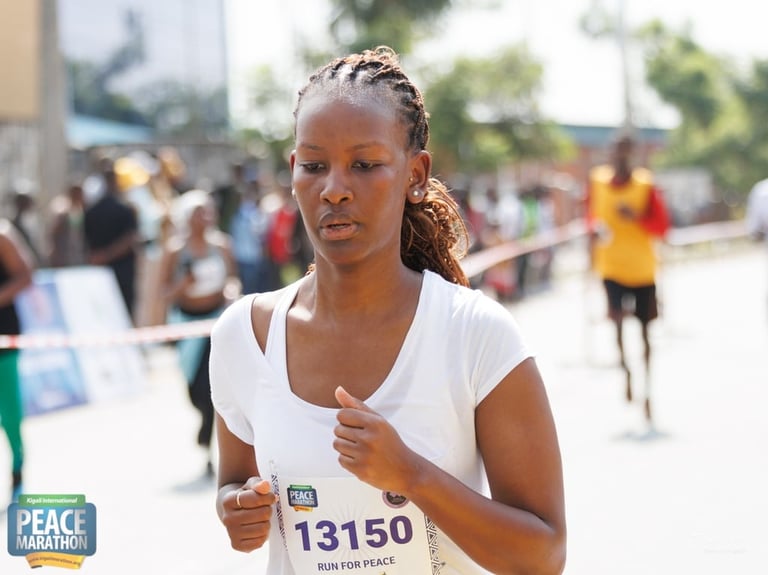 Woman runner wearing number 13150 at a peace marathon event with other participants in the background